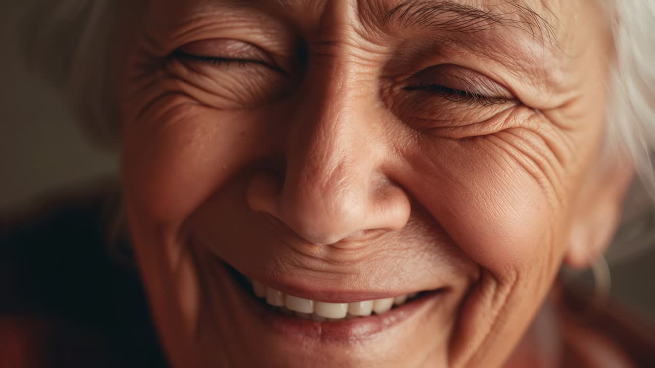 Smiling senior woman reacting to warm lens flare, opening one eye in studio close-up with camera