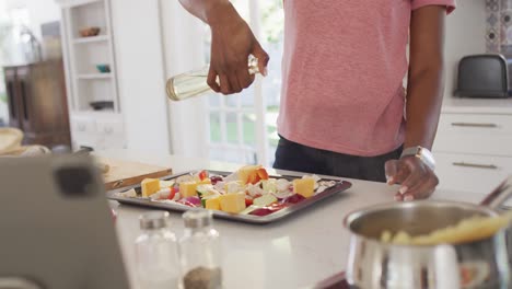 video de la sección media de una mujer afroamericana preparando comida en la cocina