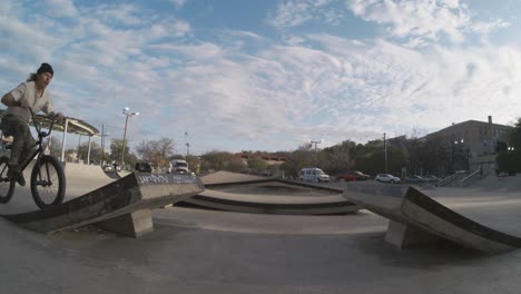 motociclista haciendo una enorme barra de aire girar fuera rampa kicker en skatepark en 800 fps extrema cámara lenta, amanecer bmx en 4k