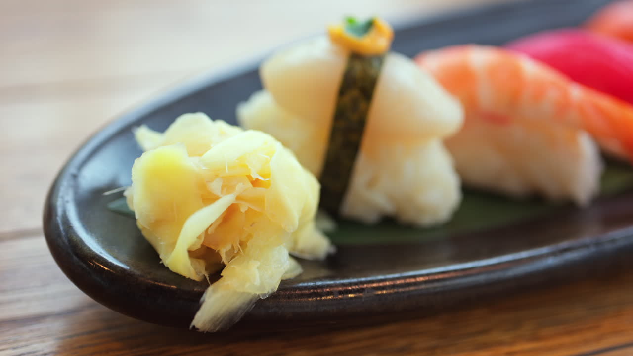 Close up of multiple nigiri on a black tray at a restaurant