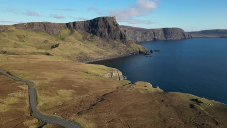 Flying-over-parked-cars-towards-rugged-coastline-at-the-viewpoint-at-Neist-Point-Isle-of-Skye-Scotland