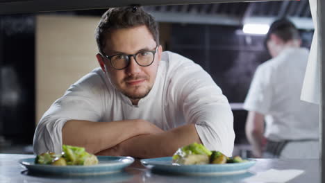 portrait of chef with ready food order in restaurant kitchen