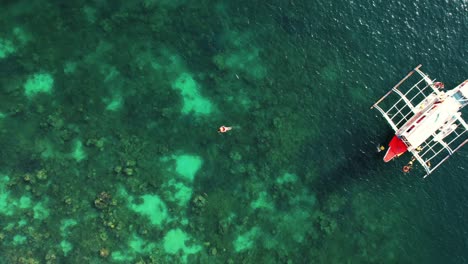 Drone-De-4k-Ascendiendo-Desde-Una-Niña-Buceando-En-Arrecife,-Coron,-Palawan-Filipinas-1