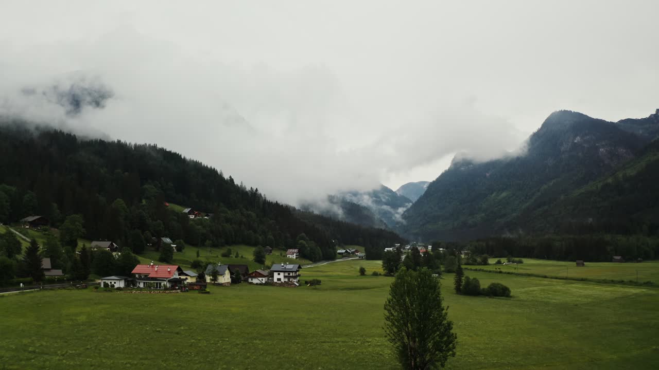 Villaggio alpino in una valle nebbiosa