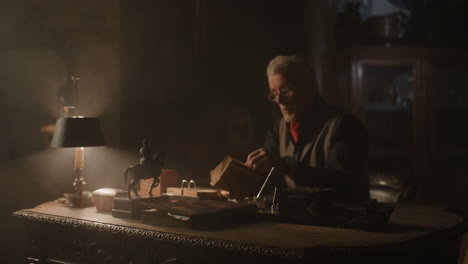 old passionate man read a book in his office at night