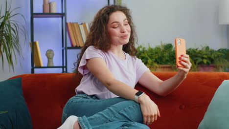 happy excited young woman making phone call conversation loudspeaker talking with friend at home