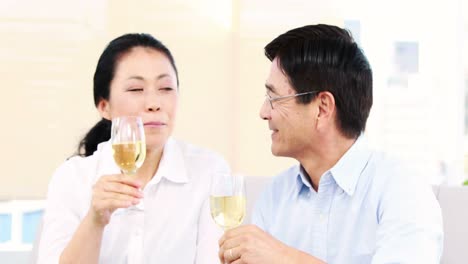 mature couple tasting champagne on the sofa