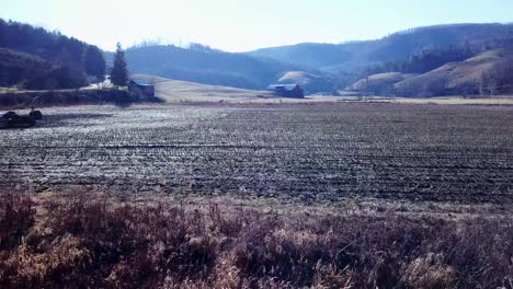 aerial of mountain farm near boone and blowing rock nc, north carolina flying over cut cornfield