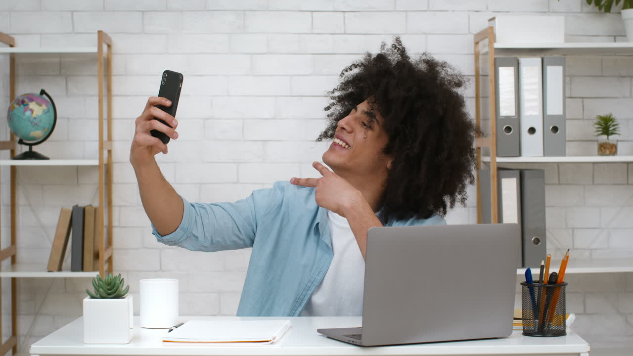 Young Man Taking a Selfie at his Desk