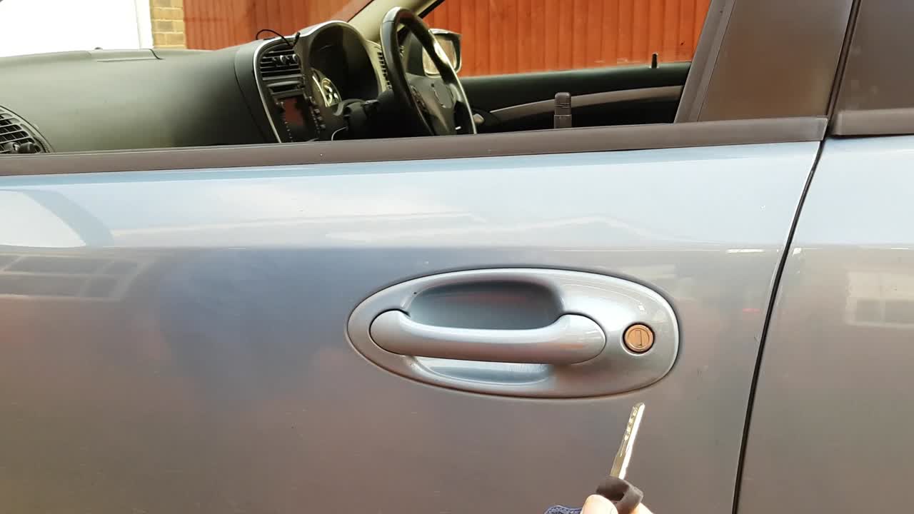 Inserting emergency key into car door lock, operating the lock by turning key and then withdrawing key from lock