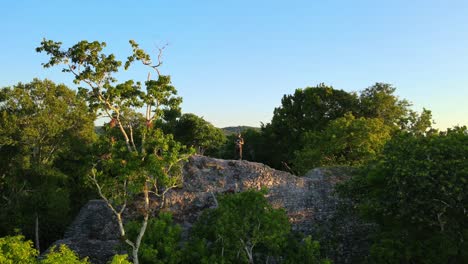 Person-standing-on-top-of-a-mayan-ruin-in-the-jungle-of-Guatemala