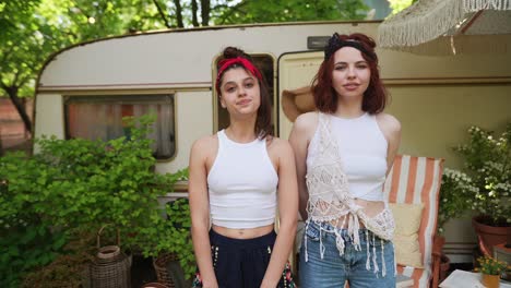 two happy friends enjoying a summer day by a camper van