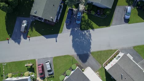 an aerial down looking view of a well kept mobile, manufactured, prefab home park of single wide and double wide houses on a sunny day