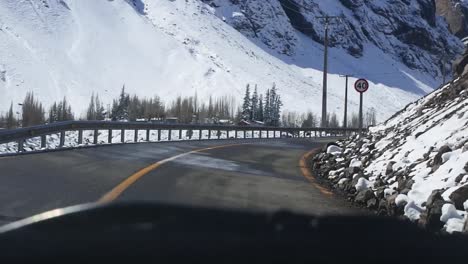 driving between snowy mountains in cajón del maipo, chile