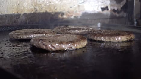 Primer-Plano-De-Hamburguesas-De-Carne-Cocinadas-En-Una-Parrilla-Abierta-En-Una-Cocina