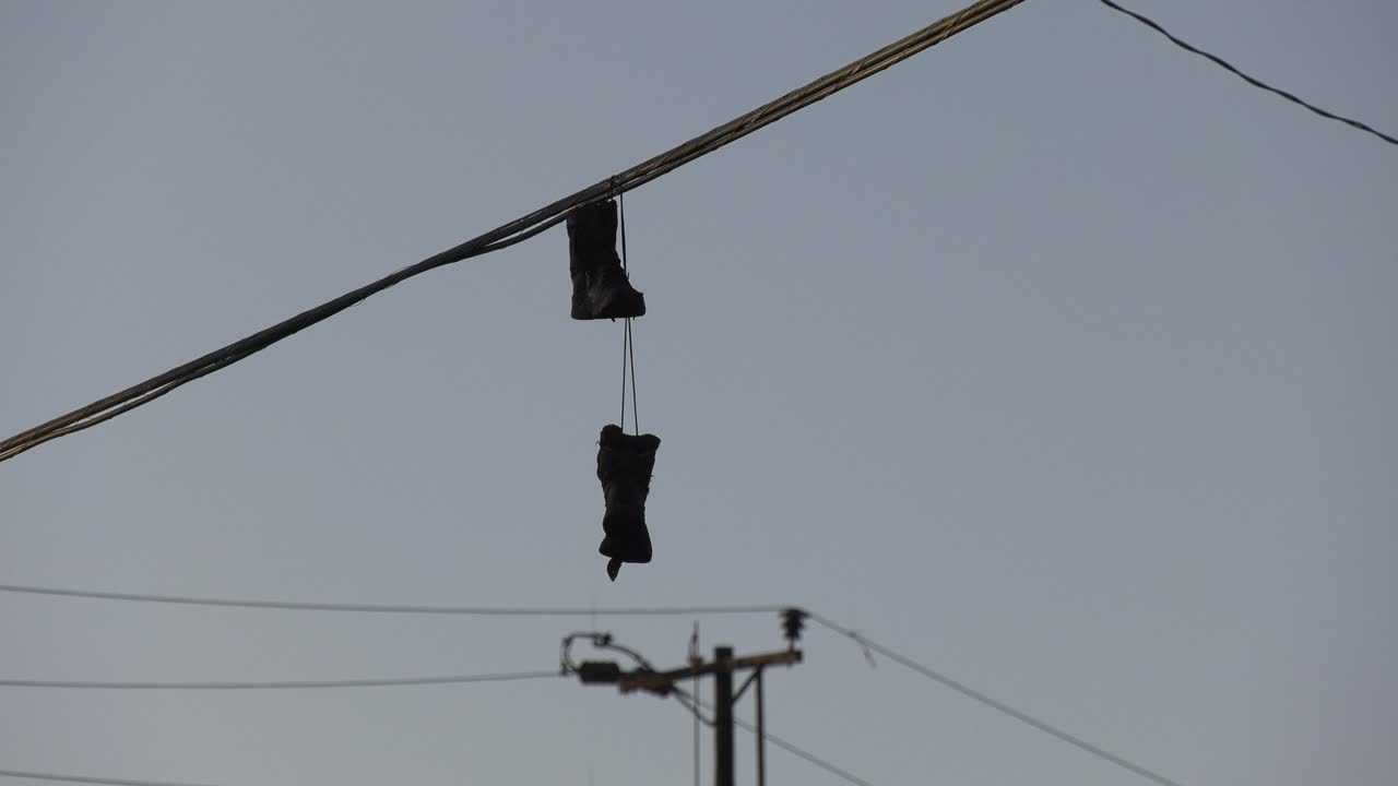 zapatos en un cable en líneas eléctricas