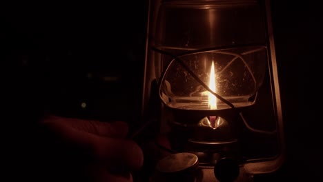 Traditional-oil-lantern-is-lit-with-match-and-glass-shade-is-lowered