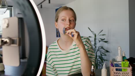 adolescente usando el rodillo de jade para el tutoriales de cuidado de la piel