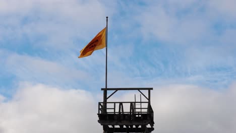 yellow flag waving on a tower