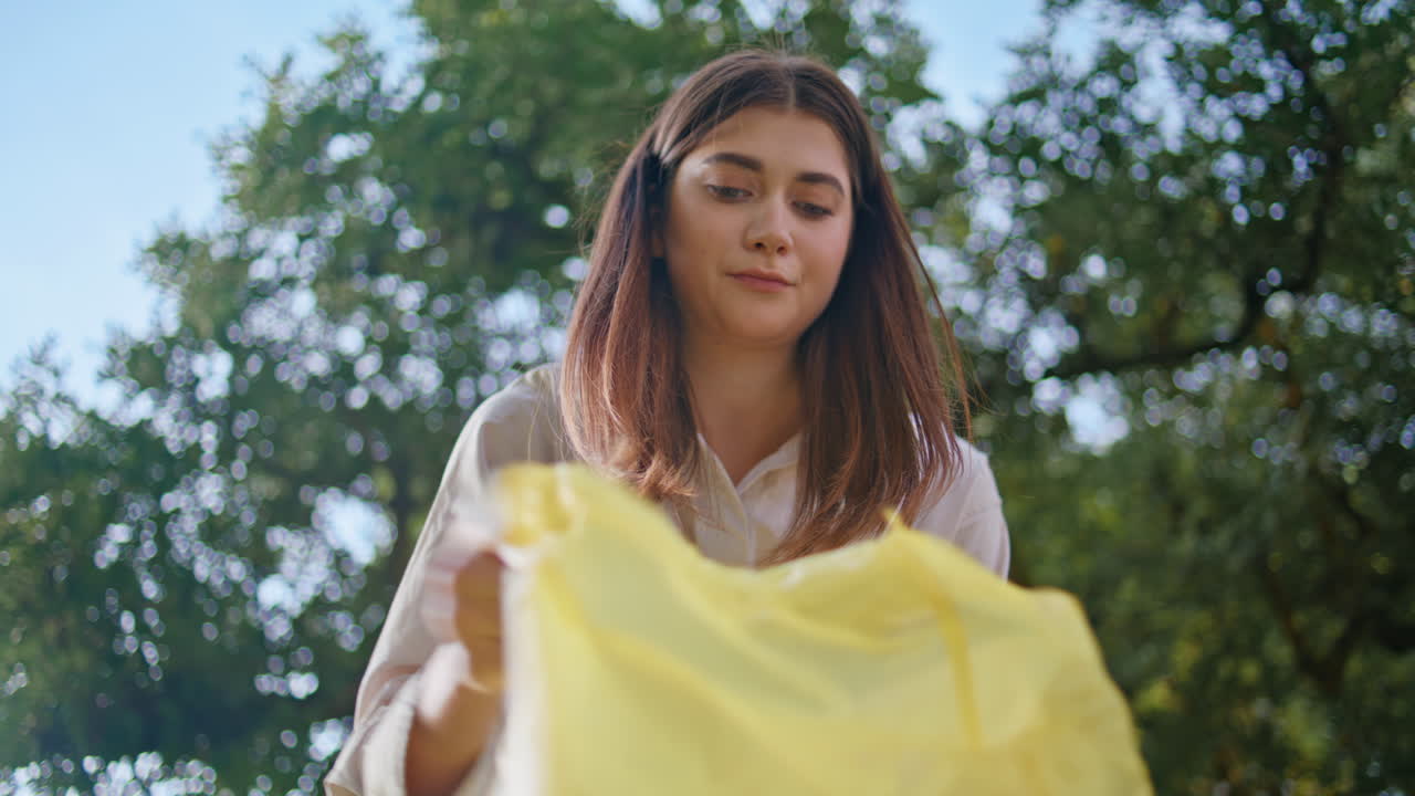 공원에서 플라스틱 가방을 고 환경을 깨하게 하는 여성 자원봉사자