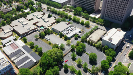 parking lot with green trees and roof of office buildings in american town