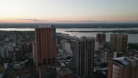 Aerial-flyover-drone-view-of-Asuncion-city-buildings-in-Paraguay,-next-to-the-river