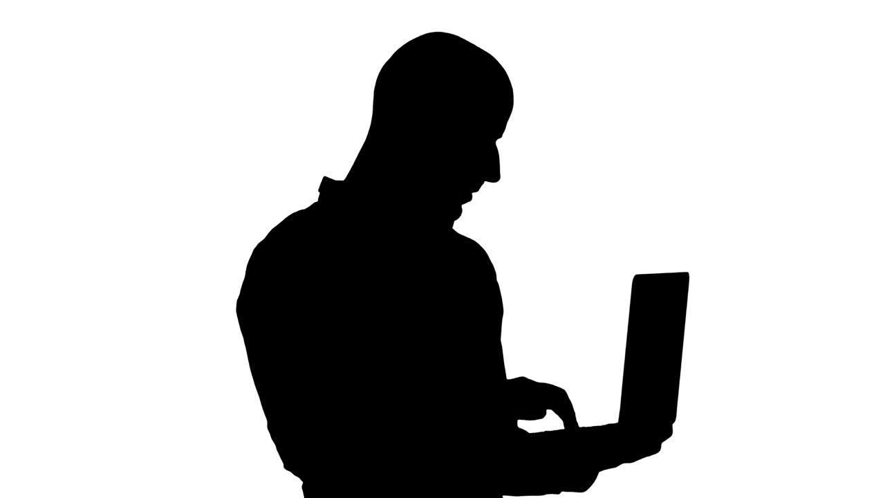 silueta joven empresario de oriente medio, de pie y escribiendo en una computadora portátil cuando la sostiene en sus manos