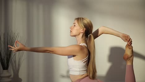 young blonde woman of american appearance doing squat exercises with weights in a modern gym young blonde woman of american appearance doing squat exercises with weights in a modern gym developing leg muscles modern gym with large panoramic windows