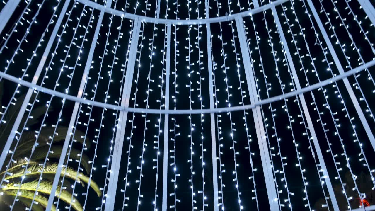 tiro inclinado hacia abajo dentro de la decoración de relámpagos navideños, la mujer se aleja de la cámara