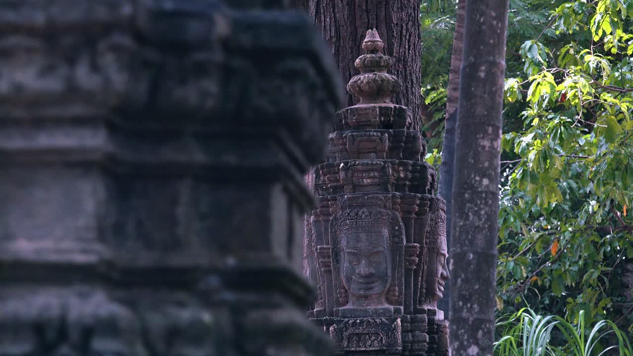 tiro deslizante que revela tallas faciales de piedra khmer cerca de angkor wat