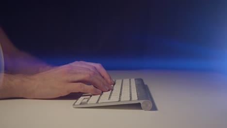 working from home male hands typing slowly on a keyboard with cinematic lens flare pausing and waiting for a reply