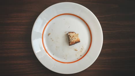 eating of piece of pie on white plate on brown wood table top view stop motion seamless