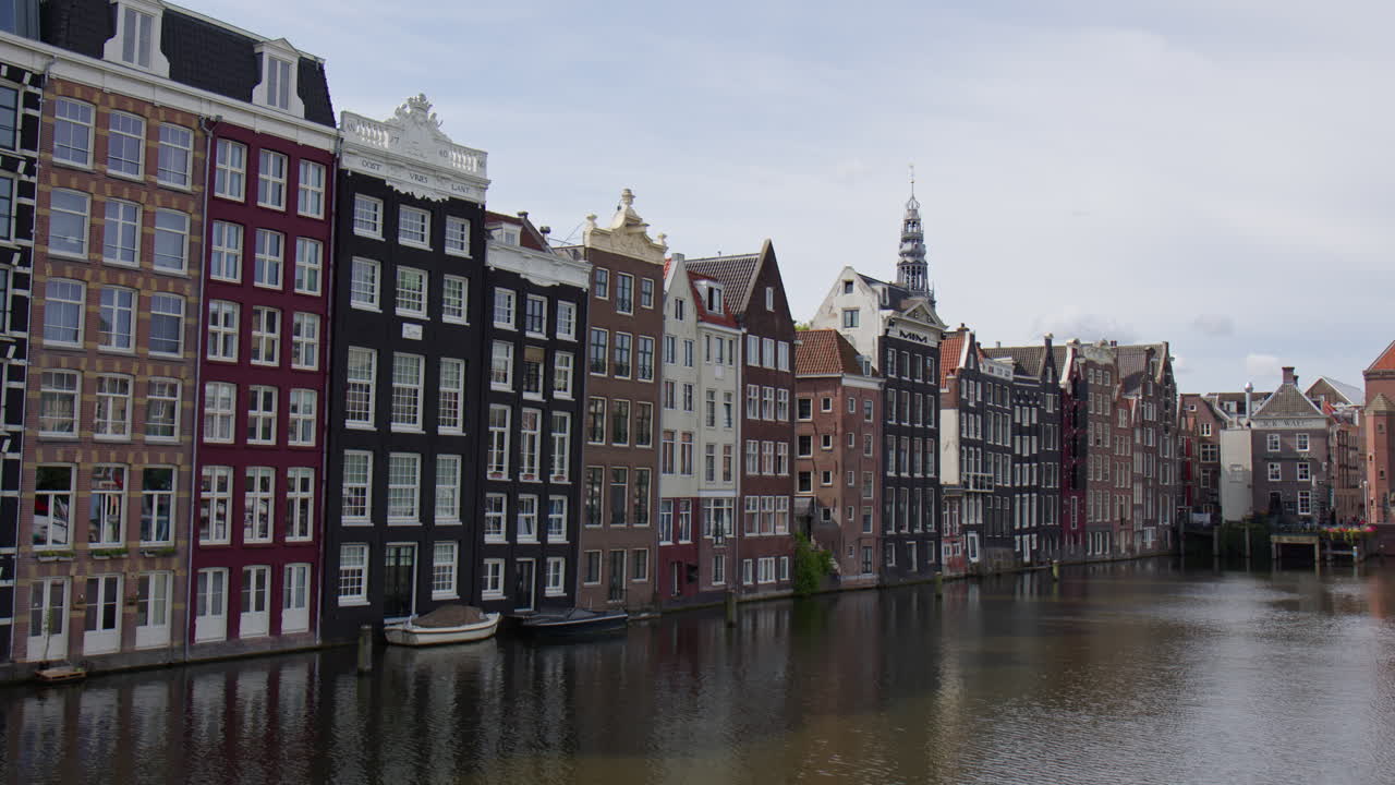 Colorful Buildings Lining The Canals At Amsterdam Capital City In The Netherlands. Static Shot