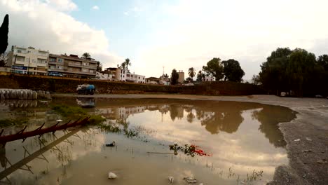 near old walls of nicosia big puddle with reflection of trees and buildings