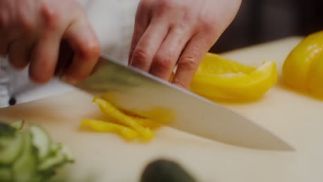 el chef cortando pimientos amarillos