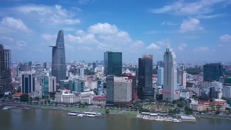 Aerial-view-of-Ho-Chi-Minh-City-skyline-featuring-key-buildings,-with-Saigon-River-waterfront-on-a-sunny,-clear-day