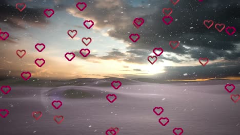 Animation-of-hearts-and-snow-falling-over-winter-landscape