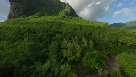 dron volando bajo sobre la playa hacia la montaña le morne brabant en mauritius