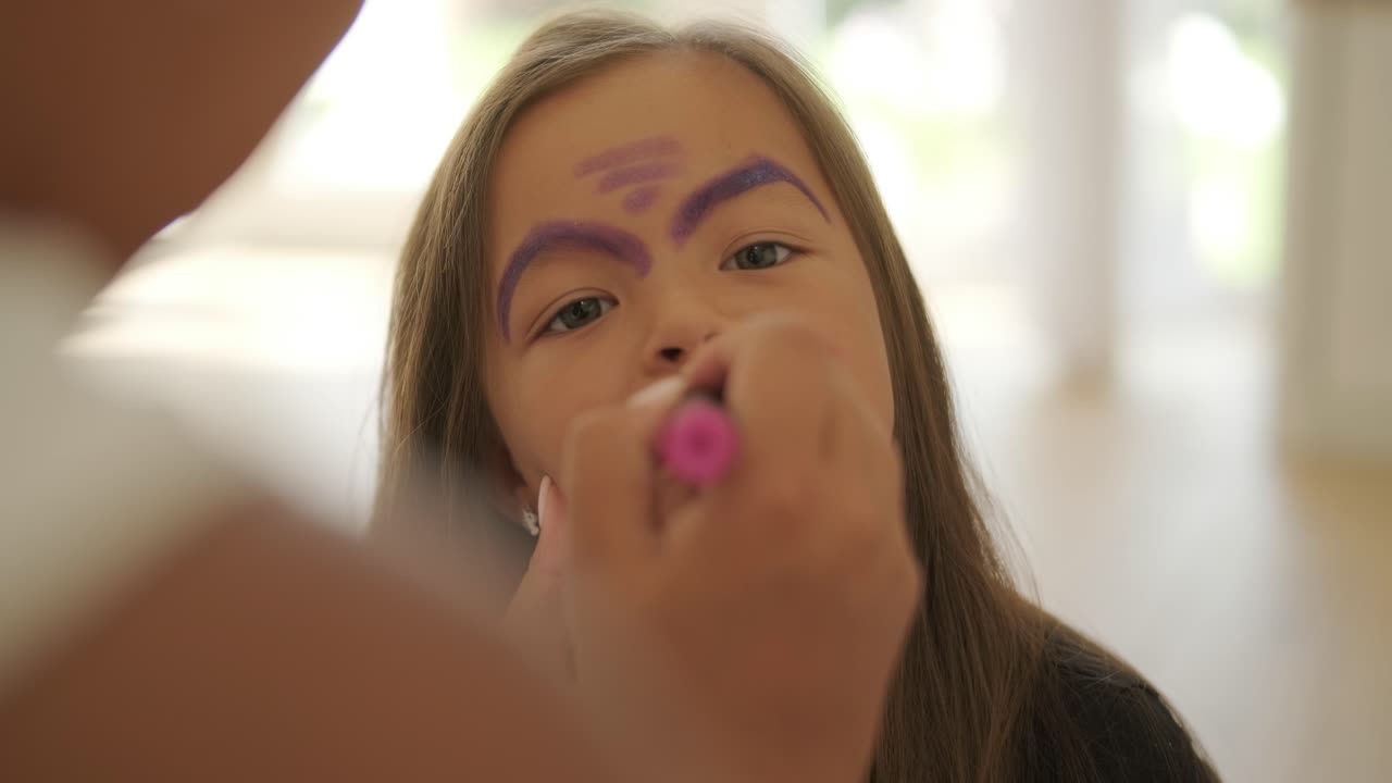 niña pequeña pintando la cara para halloween