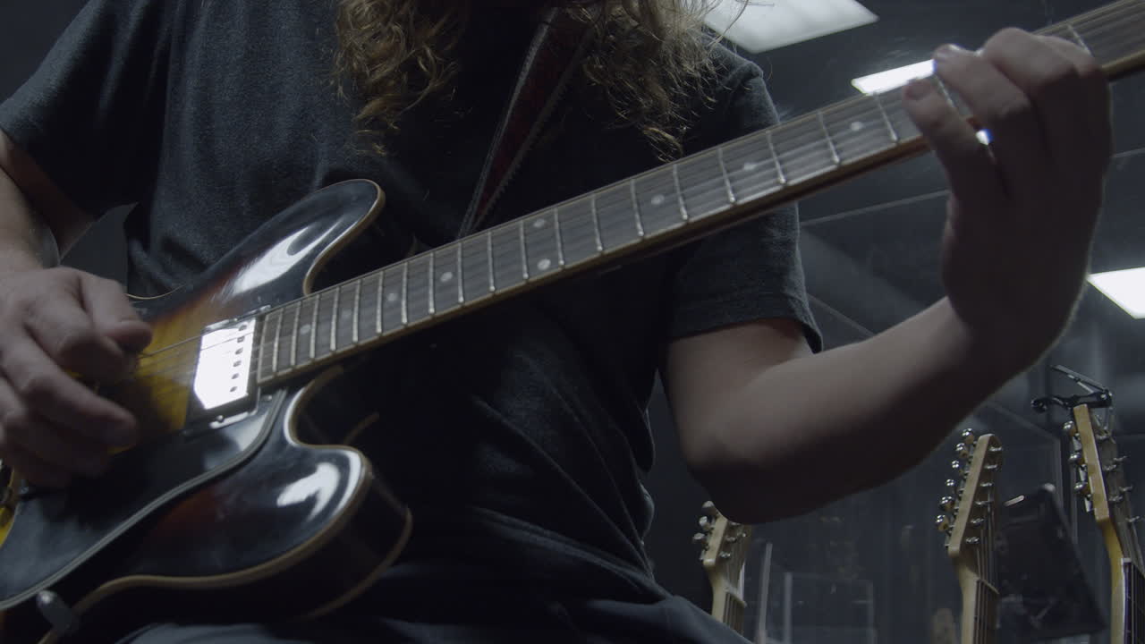 Musician playing guitar in professional recording studio (Cinematic Slow Motion)