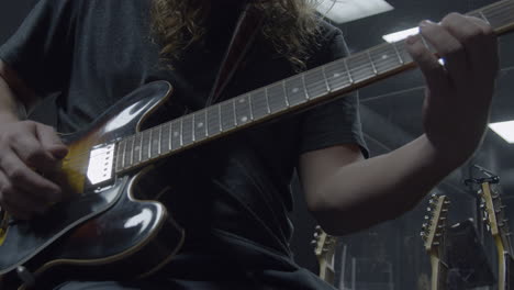 musician playing guitar in professional recording studio (cinematic slow motion)