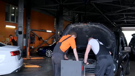 mechanics working on cars in an auto repair shop