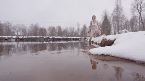una experimentada mujer de baño en el hielo en sus 40 años entra en un lago frío