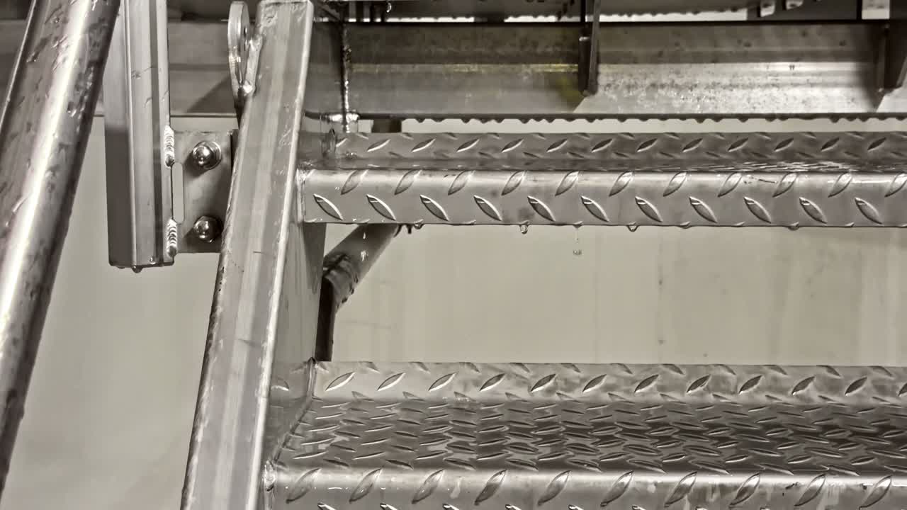 Água pinga em escadas de metal, industrial, reflexivo, clima meditativo.