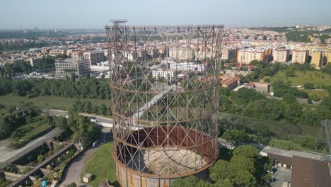 drone aéreo inclinado hacia arriba disparado sobre una antigua estructura de hierro símbolo del distrito de ostiense de roma, italia en un día soleado