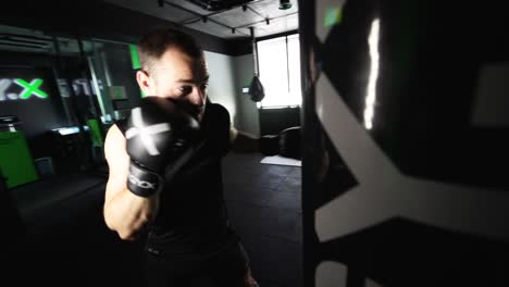 hombre entrenando con equipos de boxeo en un gimnasio