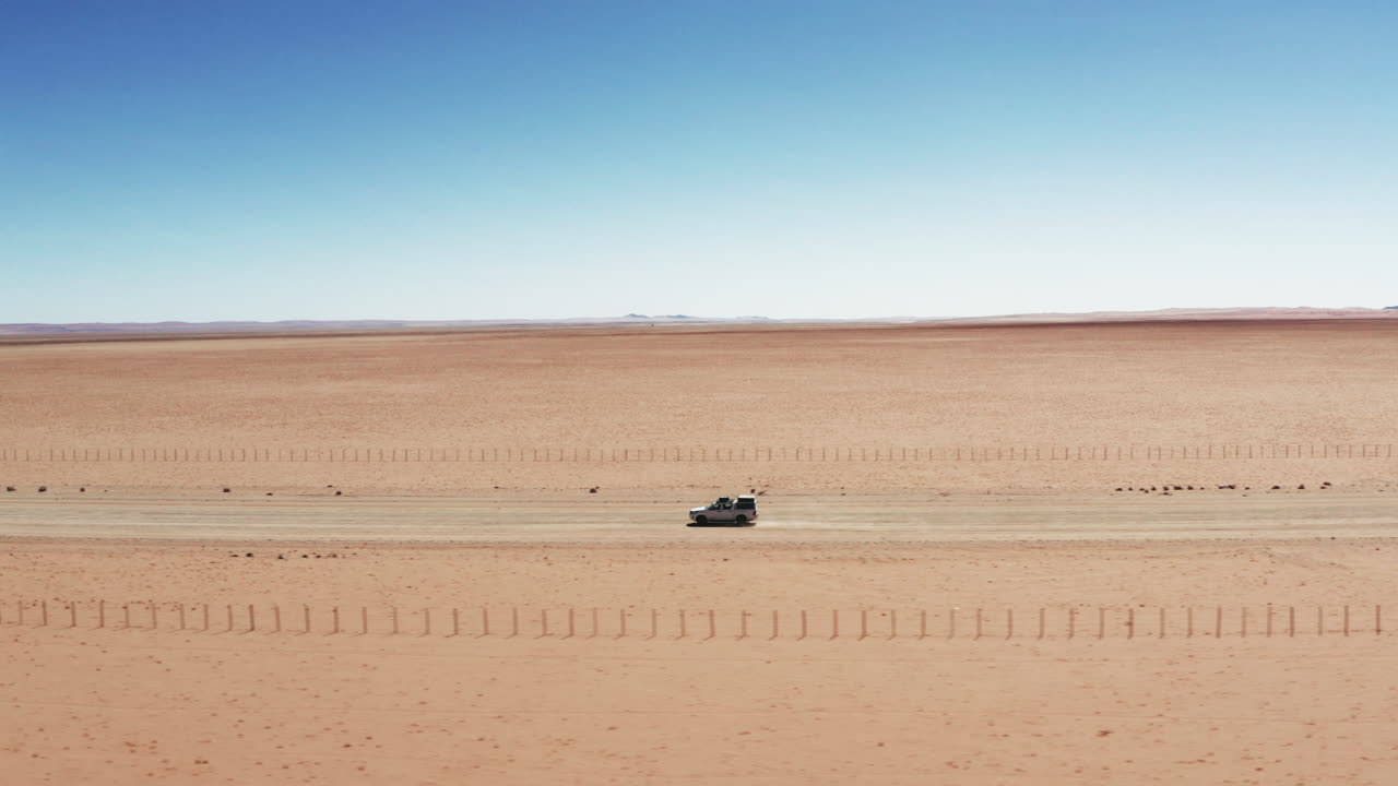 나미비아 의 모래 풍경 에서 자갈 도로 를 달리는 색 suv 자동차 - 드론 촬영