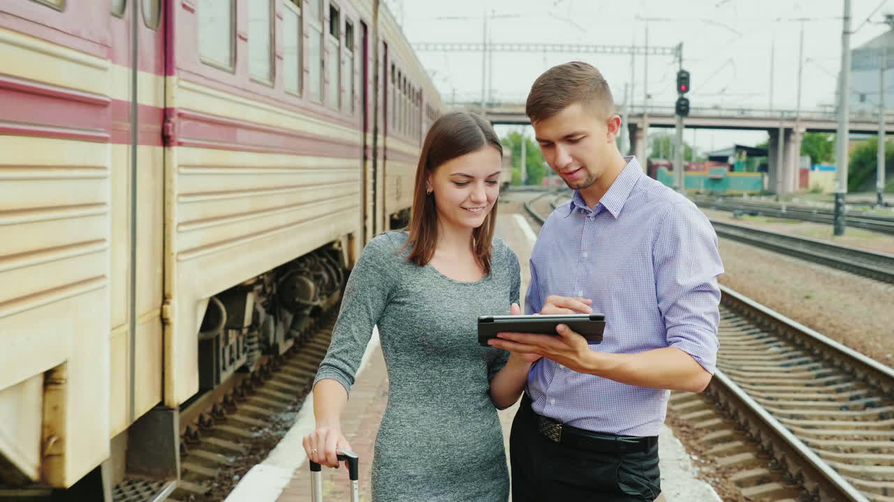 jóvenes empresarios usan una tableta en una estación de tren