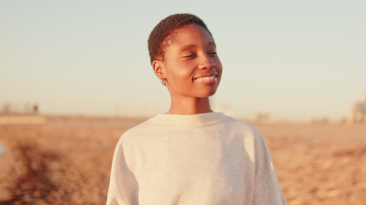 Young African American Woman Smiling on Beach at Sunset