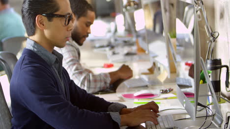 diseñadores trabajando en computadoras en oficinas modernas filmadas en r3d